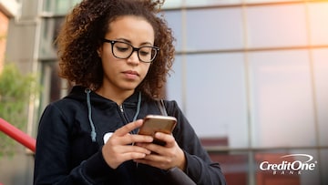 Woman on her phone checking the Credit One Bank mobile app